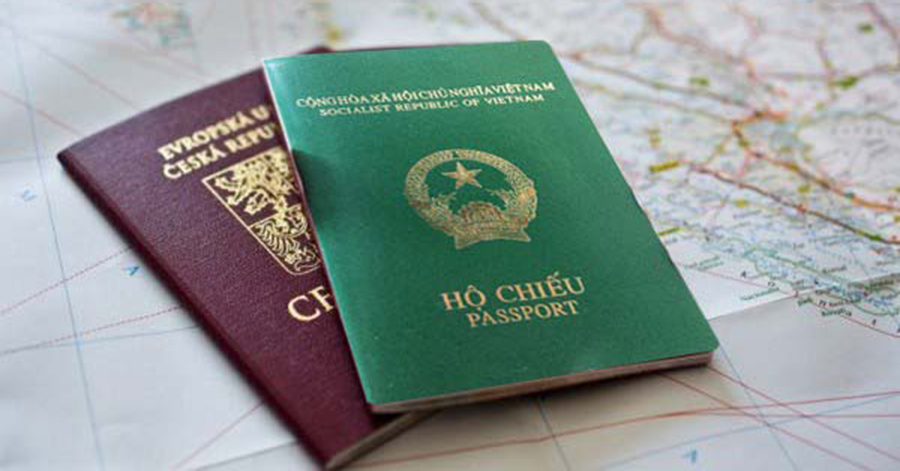 2 cuốn hộ chiếu, một cuốn màu xanh, một cuốn màu nâu đặt bên trên tấm bản đồ