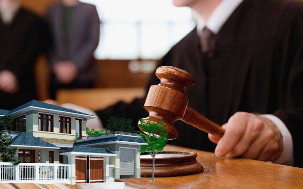 tặng cho đất đai khi chưa có giấy chứng nhận quyền sử dụng một người đang ngồi cầm búa thẩm phán, bên cạnh là hình ảnh ngôi nhà