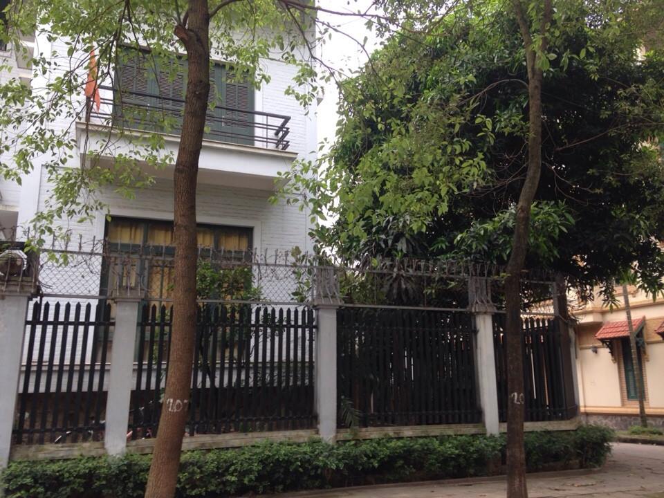 Khi mua nhà không cần xem tuổi hợp phong thủy. Ảnh chụp phía ngoài một căn biệt thự màu trắng, hàng rào bao quanh, cây lớn ngoài vỉa hè.