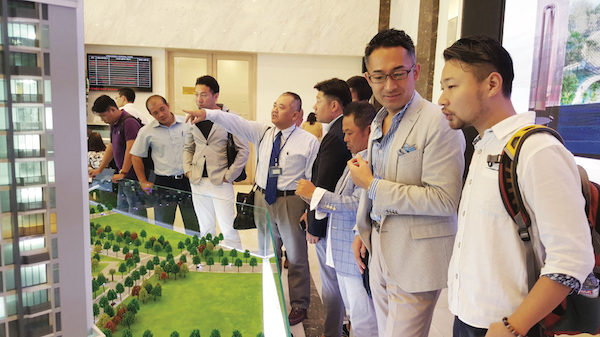 Một nhóm người đang đứng xem mô hình dự án bất động sản Việt kiều mua nhà
