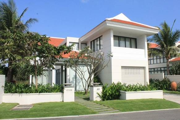 Xem tuổi xây nhà chỉ là một yếu tố nhỏ trong quá trình xây nhà. Bên ngoài một ngôi nhà kiểu biệt thự màu trắng mái đỏ, phía trước có sân vườn, xung quanh nhiều cây cối.